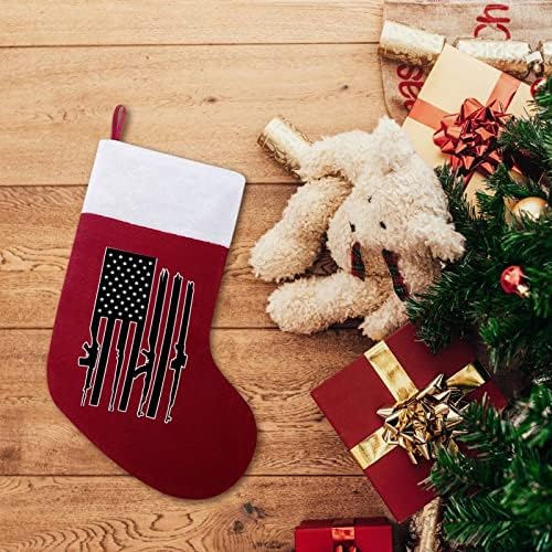 Bandeira americana com metralhadoras de metralhadoras de meias penduradas no Natal para a decoração da casa de férias em lareira de Natal da árvore de Natal