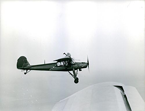 Foto vintage de Roland Toutain fazendo acrobacias em um avião voador.
